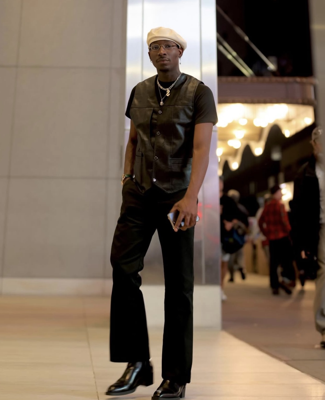 Claudio Conde wearing a black leather vest, black trousers and a cream beret