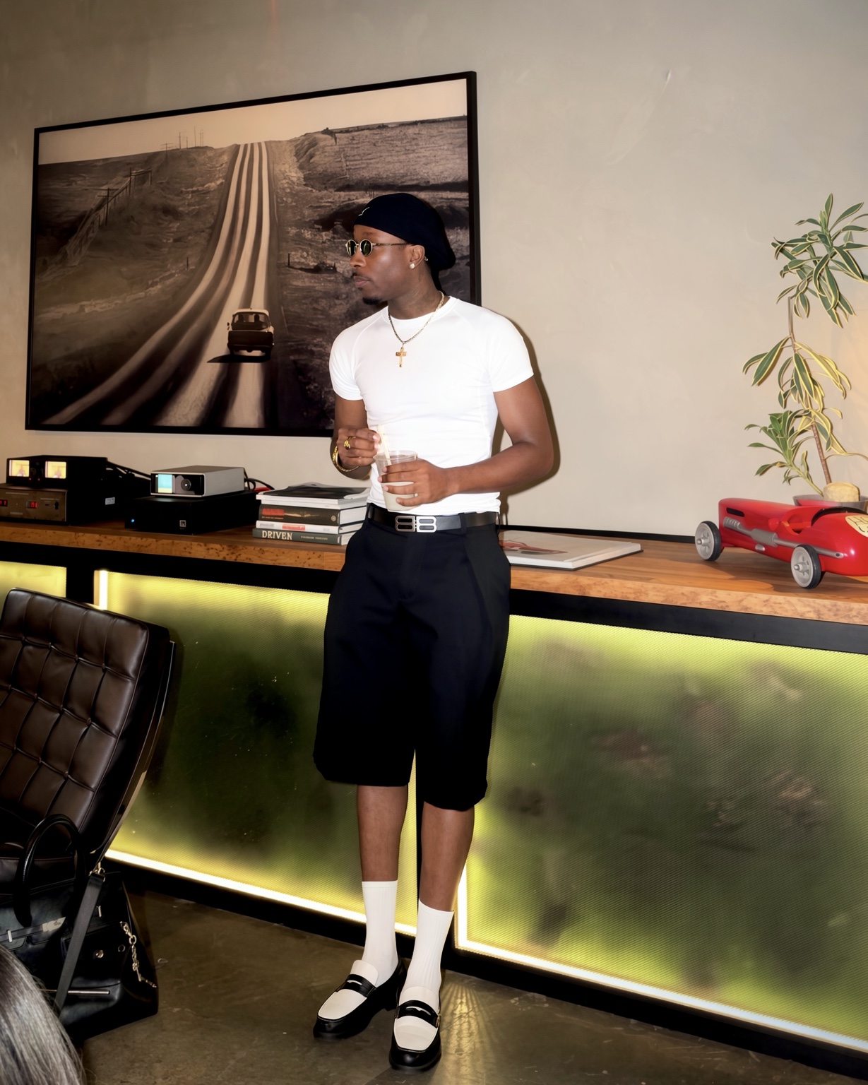 Claudio Conde wearing a white T-shirt, black shorts and loafers